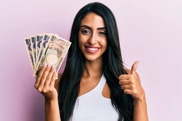 Beautiful Hispanic Woman Holding Japanese Yen Banknotes Smiling Happy Positive — Stock Photo, Image