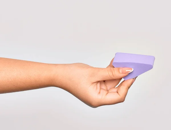 白地に紫色の化粧スポンジを持つ白人の若い女性の手 — ストック写真