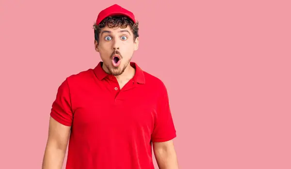 Jovem Homem Bonito Com Cabelo Encaracolado Usando Uniforme Entrega Assustado — Fotografia de Stock