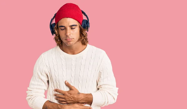 Hombre Hispano Joven Escuchando Música Usando Auriculares Con Mano Estómago —  Fotos de Stock