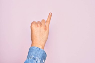 İzole edilmiş pembe arka planda parmaklarını gösteren beyaz bir gencin eli serçe parmağının söz verme sözü olduğunu gösteriyor.
