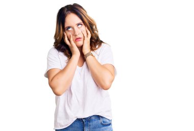 Genç, beyaz tişört giyen beyaz, güzel bir kadın. Yorgun elleri var. Yüzü, depresyonu ve üzüntüyü örtüyor. 