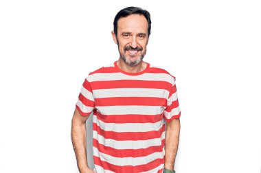 Orta yaşlı, çizgili tişört giyen yakışıklı bir adam izole edilmiş beyaz arka planda mutlu ve havalı bir gülümsemeyle dikiliyor. Şanslı kişi..