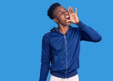 Afro-Amerikalı genç bir adam spor giyer ve el ele tutuşarak bağırır ve çığlık atar. iletişim konsepti. 