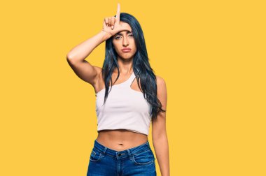 Güzel İspanyol kadın günlük kıyafetler giyiyor. Alnında parmakları olan insanlarla alay ediyor. Ezik hareketler yapıyor, alay ediyor.. 