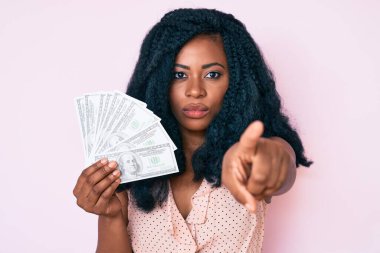 Elinde dolarlarla kamerayı işaret eden güzel bir Afrikalı kadın ve sen, kendine güvenen ciddi görünüyorsun. 