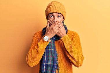 Sıradan kışlık giysiler giyen Afrikalı genç bir Amerikalı yanlışlıkla ağızlarını kapatarak şok geçirdi. gizli kavram. 