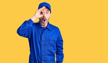 Tamirci üniforması giyen orta yaşlı yakışıklı adam şaşırmış yüz ifadesiyle şok olmuş, parmaklarından bakan gözler. İnançsız ifade. 