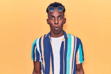 Yazlık giysiler ve güneş gözlüğü takan Afro-Amerikalı genç adam şaşıracak şekilde ağzı açık kalmış, korkmuş ve hayrete düşmüştü. 
