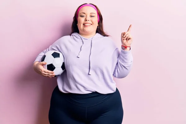 Mladý Velikost Žena Drží Fotbalový Míč Úsměvem Šťastný Ukazující Rukou — Stock fotografie