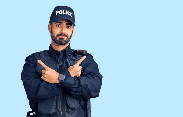 Jonge Spaanse Man Draagt Politie Uniform Wijzend Naar Beide Kanten — Stockfoto