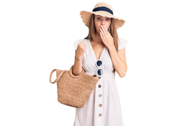 若い美しいブロンドの女性は夏のドレスと手で口をカバーウィッカーハンドバッグを身に着けている ショックを受け 間違いを恐れている 驚きの表情 — ストック写真