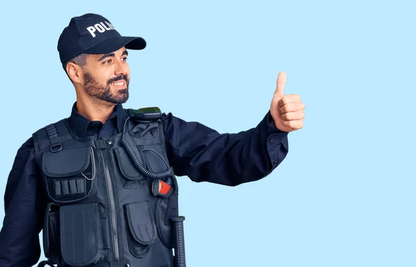 Jovem Hispânico Vestindo Uniforme Polícia Olhando Orgulhoso Sorrindo Fazendo Polegares — Fotografia de Stock