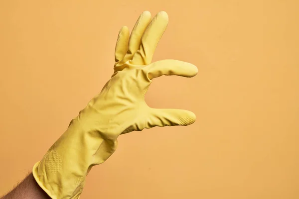 Hand Caucasian Young Man Cleaning Glove Isolated Yellow Background Picking — Stock Photo, Image