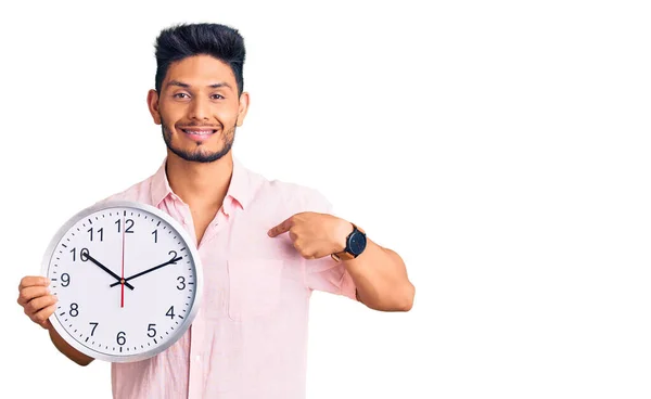 Guapo Joven Latinoamericano Sosteniendo Gran Reloj Señalando Con Dedo Uno — Foto de Stock