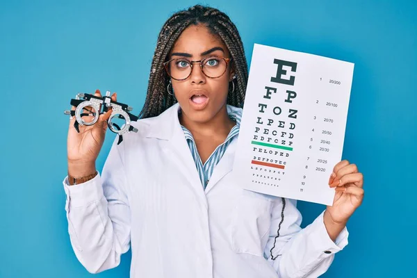 若いですアフリカ系アメリカ人の光量子眼鏡を保持し 衝撃的な顔の医学検査 懐疑的で皮肉 驚いていますオープン口 — ストック写真