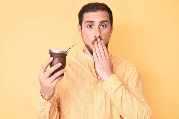 Young Handsome Man Drinking Mate Infusion Covering Mouth Hand Shocked — Stock Photo, Image