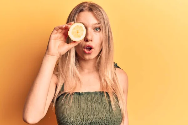 Mladá Blondýnka Drží Citron Vyděšený Ohromen Otevřenými Ústy Pro Překvapení — Stock fotografie