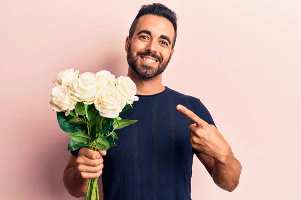 Jovem Hispânico Segurando Flores Sorrindo Feliz Apontando Com Mão Dedo — Fotografia de Stock