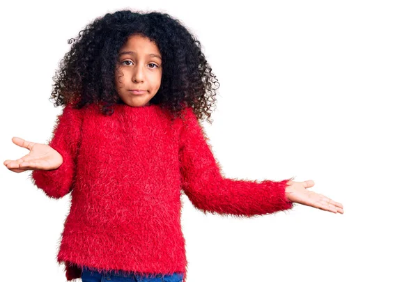 カジュアルな冬のセーターを着て巻き毛を持つアフリカ系アメリカ人の子供は 腕や手を上げて混乱表現 疑わしい概念 — ストック写真