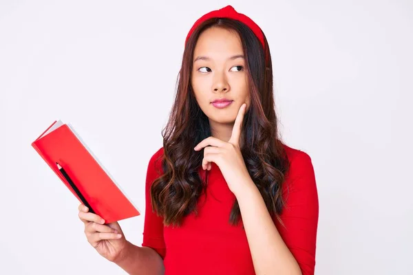 Jovem Menina Chinesa Bonita Segurando Livro Rosto Sério Pensando Sobre — Fotografia de Stock