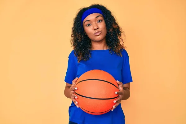年轻的非洲裔美国女人拿着篮球比赛 看着摄像机吹一个吻是可爱和性感的 爱的表达 — 图库照片
