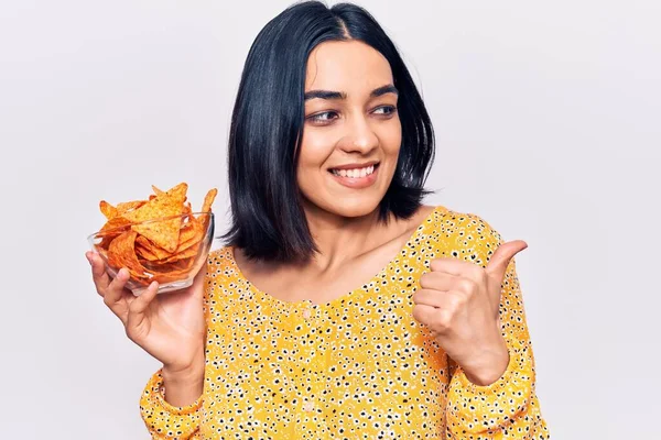 Genç Güzel Latin Bir Kadın Elinde Patates Cipsi Tutarken Başparmağını — Stok fotoğraf