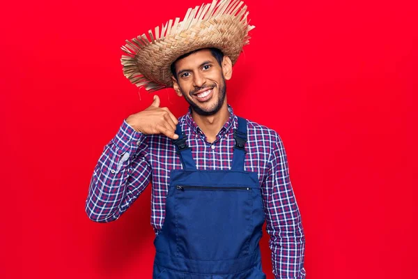 Joven Latino Con Sombrero Granjero Delantal Sonriendo Haciendo Gesto Telefónico —  Fotos de Stock