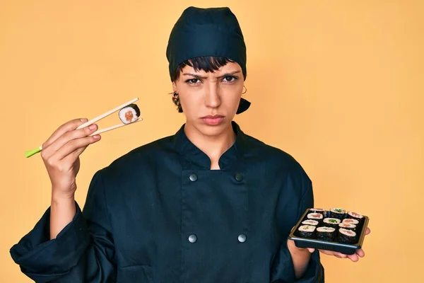 Mulher Bonita Morena Chef Segurando Sushi Usando Pauzinhos Céticos Nervosos — Fotografia de Stock