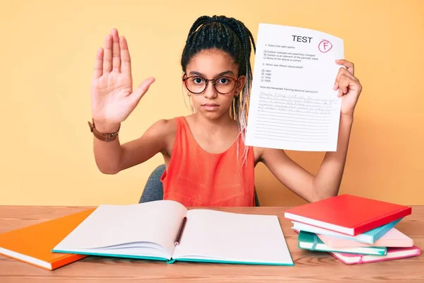 Young african american girl child with braids showing failed exam with open hand doing stop sign with serious and confident expression, defense gesture