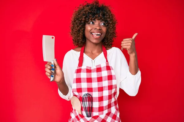 Joven Mujer Afroamericana Con Delantal Cocinero Sosteniendo Cuchillo Apuntando Pulgar —  Fotos de Stock