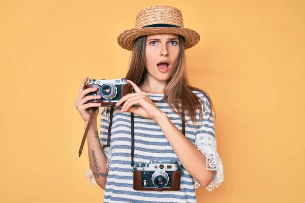 衝撃的な顔でヴィンテージカメラを保持美しい白人観光客の女性 懐疑的で皮肉を探して オープン口で驚いて — ストック写真