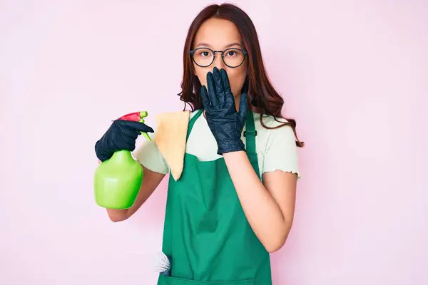 Young Beautiful Chinese Girl Wearing Apron Holding Sprayer Covering Mouth — Stock Photo, Image