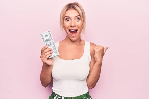 Junge Schöne Blonde Frau Hält Dollarscheine Über Isoliertem Rosa Hintergrund — Stockfoto