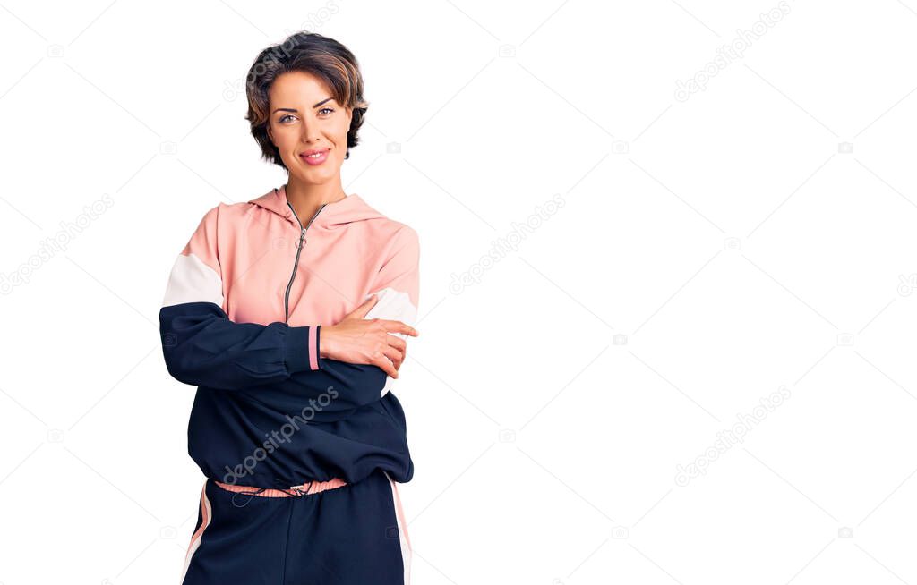 Young beautiful woman wearing sportswear happy face smiling with crossed arms looking at the camera. positive person. 
