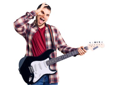 Elektro gitar çalan genç yakışıklı adam gülümsüyor. Mutluluktan gülümsüyor. 