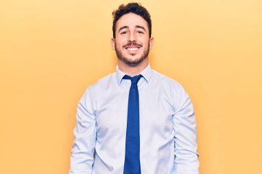 Yüzünde mutlu ve havalı bir gülümseme olan iş kıyafetleri giyen genç İspanyol bir adam. şanslı kişi. 