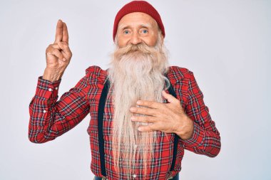 Yaşlı, gri saçlı, uzun sakallı, hippi görünümlü, yün şapkalı, gülümseyen, elleri göğsünde ve parmakları havada, sadakat yemini eden yaşlı bir adam. 