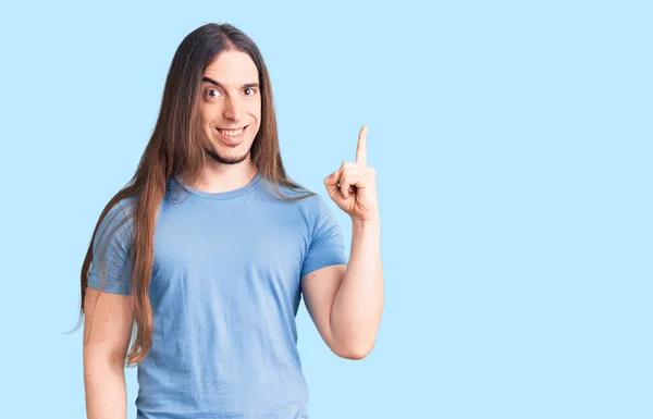 Young Adult Man Long Hair Wearing Casual Clothes Pointing Finger — Stock Photo, Image