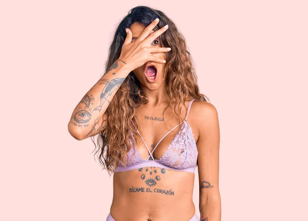 Mulher Hispânica Jovem Com Tatuagem Vestindo Lingerie Espreitando Choque Cobrindo — Fotografia de Stock