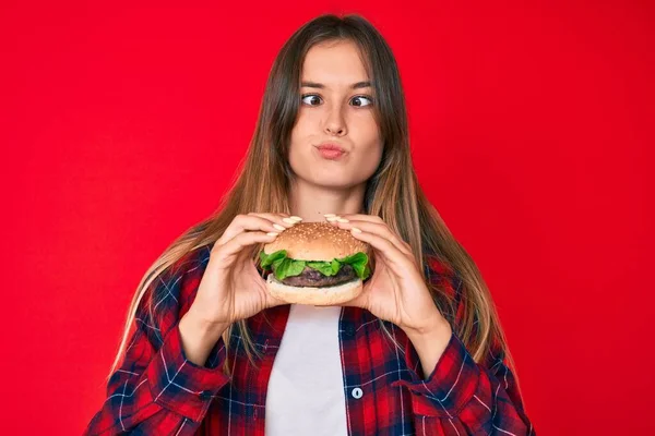 Gyönyörű Kaukázusi Eszik Egy Ízletes Klasszikus Burger Hogy Hal Arcát — Stock Fotó