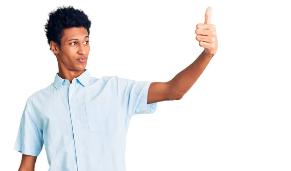 身穿休闲装的年轻的非洲裔美国人看上去很自豪 微笑着向旁边竖起大拇指 — 图库照片