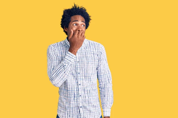 アフリカ系アメリカ人の男性が普段着の服を着ていて 口の中で爪をかむ手でストレスと緊張を感じています 不安の問題 — ストック写真
