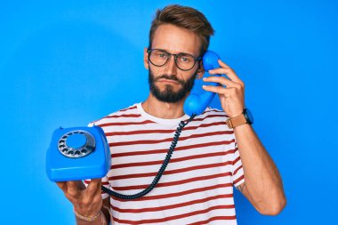 Sakallı, antika telefon tutan yakışıklı beyaz bir adam. Depresyonda ve üzüntüden ağlıyor. Öfkeli ve korkmuş. hüzünlü ifade. 