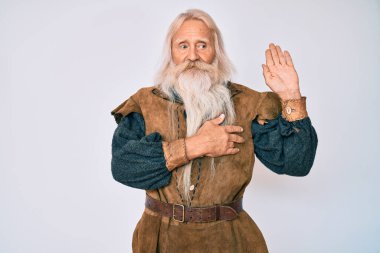 Gri saçlı ve uzun sakallı yaşlı bir adam. Geleneksel Viking kostümü giyiyor. Göğüs ve avuç içi açık küfürler edip sadakat yemini ediyor. 