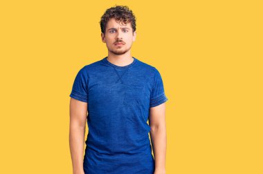 Kıvırcık saçlı, depresif giyinmiş, sıkıntıdan korkan sinirli ve korkmuş genç yakışıklı bir adam. hüzünlü ifade. 