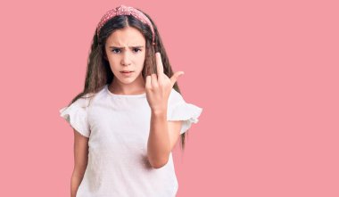 Cute hispanic child girl wearing casual white tshirt showing middle finger, impolite and rude fuck off expression 