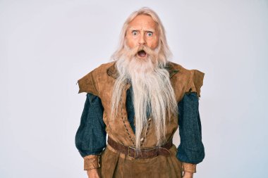 Gri saçlı, uzun sakallı, Viking kostümü giyen yaşlı bir adam. Şaşırmış ve şaşırmış bir ifade, korku ve heyecanlı bir yüz ifadesi var.. 