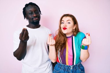 Irklar arası giyinen, gündelik kıyafetler giyen, ellerle jest yapan, maaş ödemesi isteyen milyonerlik işleri olan bir çift. 