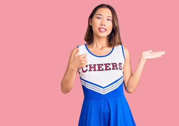 年轻美丽的中国姑娘 身穿啦啦队队长制服 手牵手 竖起大拇指做手势 笑容满面 笑容满面 — 图库照片